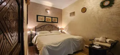 a bedroom with a bed with white sheets and pillows at Riad Dar Si Driss in Marrakech