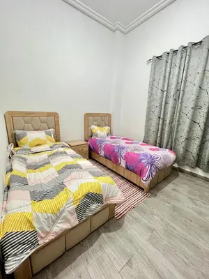 two beds sitting in a room with curtains at MyZo Superbe Appartement familial bien situé à Marrakech in Marrakech