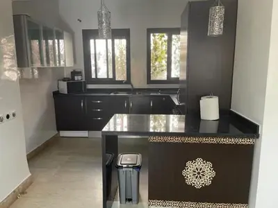 a kitchen with black cabinets and a counter top at Merveilleuse Marrakech! in Marrakech