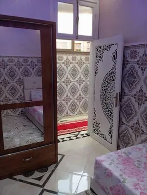 a room with a mirror and a bed and a window at Redone in Marrakech