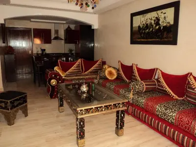 a living room with red couches and a table at RESIDENCE HAMZA Cosy appartement only family à Gueliz in Marrakech