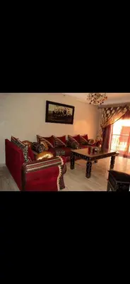 a living room with red couches and a table at RESIDENCE HAMZA Cosy appartement only family à Gueliz in Marrakech