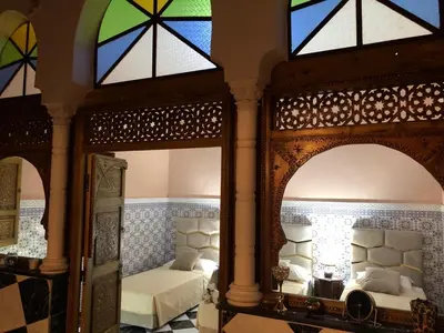 a bedroom with a bed and two mirrors at Riad Ramona lQariya seyaheya in Marrakech