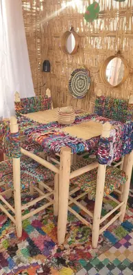 a wooden table and bench with a table and chairs at Riad Ramona lQariya seyaheya in Marrakech