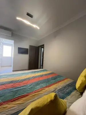 a bedroom with a bed with a colorful bedspread at Appartement aéroport Marrakech in Marrakech