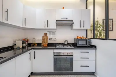a white kitchen with white cabinets and a microwave at RIAD LE M neuf et contemporain in Marrakech
