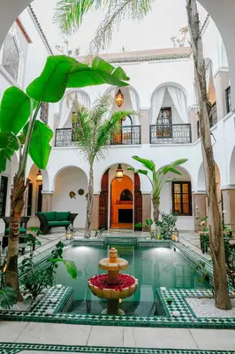 a courtyard with a fountain in the middle of a building at RIAD ELNOUJOUM in Marrakech