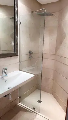 a bathroom with a shower with a sink and a glass shower door at Superbe appartement de luxe a l'hivernage marrakech in Marrakech