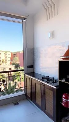 a kitchen with a counter and a large window at Superbe appartement de luxe a l'hivernage marrakech in Marrakech