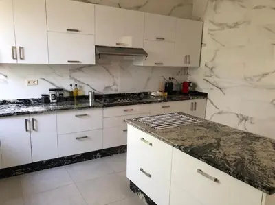 a kitchen with white cabinets and a granite counter top at Private Villa with private Chef optional in Marrakech
