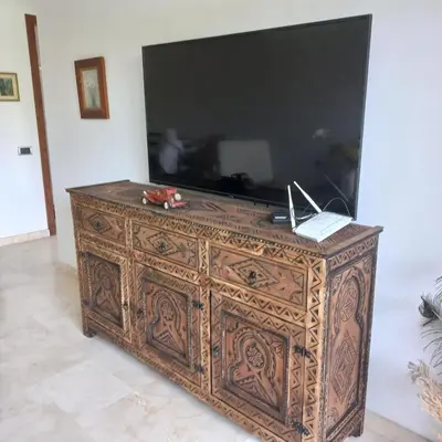 a wooden dresser with a large television on top of it at Appartement de luxe Prestigia in Marrakech