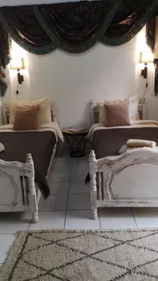 a bedroom with two beds and a rug at maison noé , residence al quaria ab40 in Marrakech