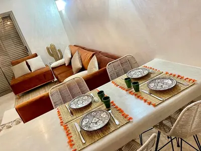 a dining table with two plates and a couch at Pearl Garden Studio Cozy Panoramic Charming sunny Terrace Piscine in Marrakech