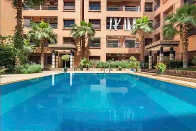 a large blue swimming pool in front of a building at Appartement Marrakech Hivernage N2 RESIDENCE CAPRICE PALACE in Marrakech