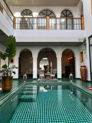 an indoor swimming pool with green tiles in a house at Riad Darchica in Marrakech