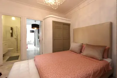 a bedroom with a bed and a chandelier at Riad avec piscine - Wifi- petit déjeuner - Bon Emplacement in Marrakech