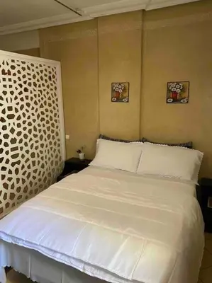 a bedroom with a bed with white sheets and pillows at superbe appartement à Gueliz in Marrakech