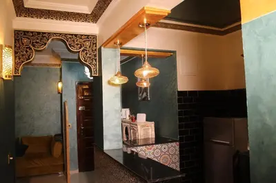 a kitchen with a counter with a refrigerator and a mirror at Appartement style Riad, 2 chambres, ambiance cosy in Marrakech