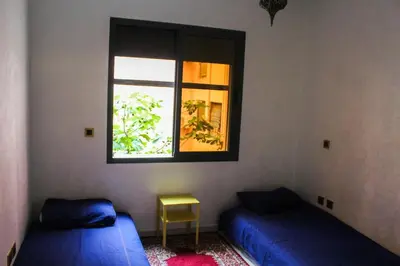 a bedroom with two beds and a window at Appartement style Riad, 2 chambres, ambiance cosy in Marrakech