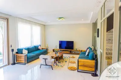 a living room with blue couches and a tv at Villa Boutique Amani in Marrakech