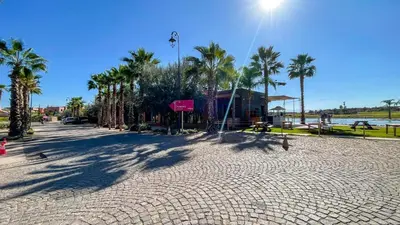 a cobblestone street with palm trees and a building at Villa Atlas piscine chauffée à Marrakech in Marrakech