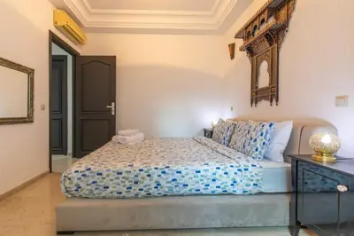 a bedroom with a bed and a mirror on the wall at Central Cosy Appartement Avec Piscine in Marrakech