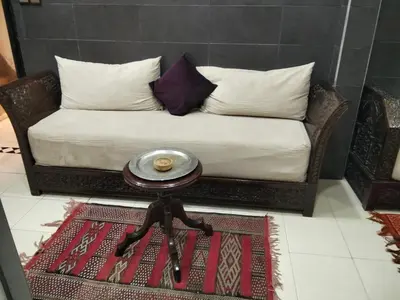 a couch with pillows and a table in a room at DAR IJLAL in Marrakech