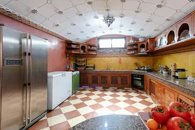 a kitchen with stainless steel appliances and a checkered floor at Riad Tranquility - A Timeless Marrakech Haven in Marrakech