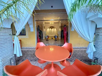 a red table and chairs in a hallway at Riad Safran Ralya in Marrakech
