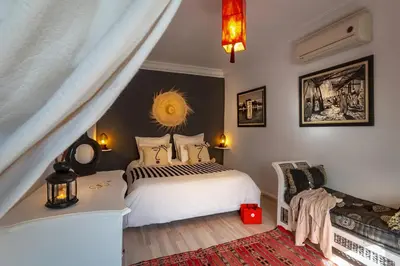 a bedroom with a white bed and a red rug at Villa Cosy Piscine Proche centre-ville 4 suites in Marrakech