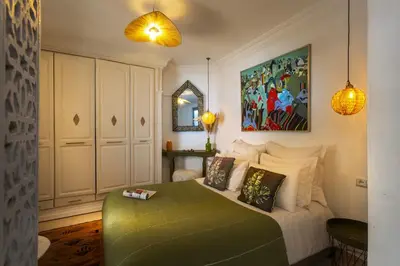 a bedroom with a bed with pillows and a mirror at Villa Cosy Piscine Proche centre-ville 4 suites in Marrakech