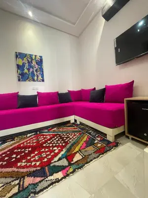 a living room with a purple couch and a tv at Riad hotel Cecil in Marrakech