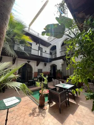a patio with a table and chairs and a building at Riad Jnan El Cadi in Marrakech