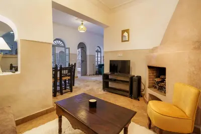 a living room with a table and a fireplace at Riad Coco Marrakech in Marrakech
