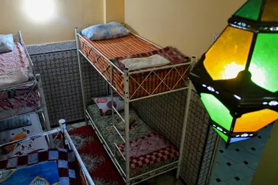 a room with two bunk beds and a lamp at Hostel kif kif annex in Marrakech