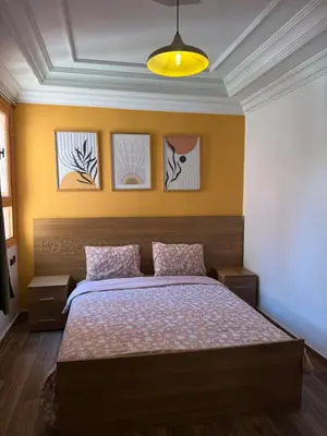 a bedroom with a bed with three pictures on the wall at Julie's AIRPORT Apartment in Marrakech