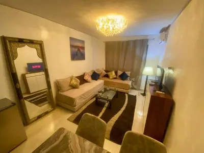 a living room with a couch and a mirror at Chic & Cosy au coeur d’hivernage in Marrakech