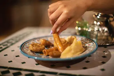 a person holding a stick of food on a plate at Riad Chez Henriette in Marrakech