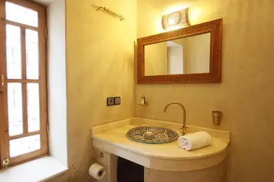 a bathroom with a sink and a mirror at Riad Chez Henriette in Marrakech