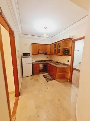 a kitchen with wooden cabinets and a white refrigerator at AL ANDALOUS 6 - une chambre in Marrakech