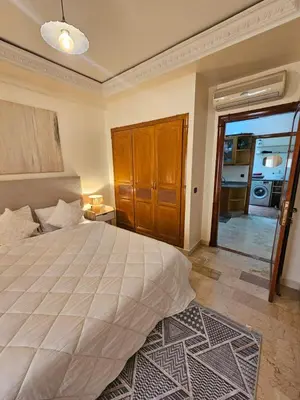 a bedroom with a large bed and a door to a kitchen at AL ANDALOUS 6 - une chambre in Marrakech