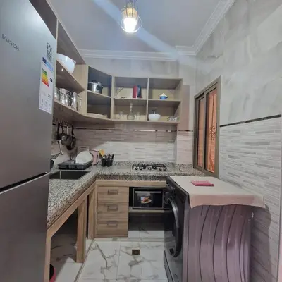 a kitchen with a sink and a stove top oven at Bel appartement de 2 chambres M in Marrakech