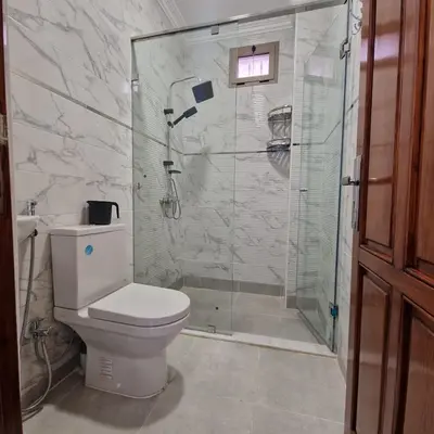 a bathroom with a toilet and a glass shower at Bel appartement de 2 chambres M in Marrakech