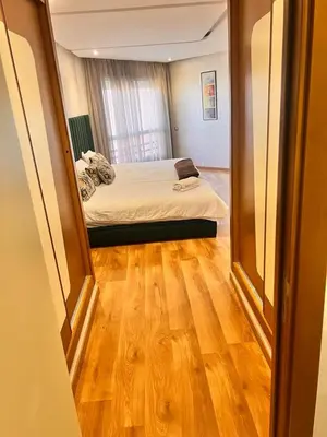 a bedroom with a bed and a wooden floor at LUXURY APPART Pool view Riad Garden in Marrakech