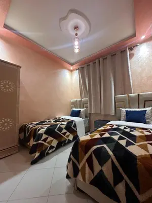 a room with two beds and a ceiling at Charmant Appartement 2 Chambres pour Sejours en Famille Marrakech in Marrakech