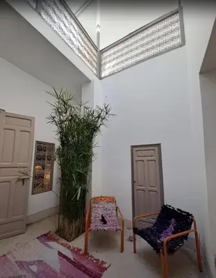a room with two chairs and a skylight at Riad Slima - riad privatisé -Marrakech au coeur de la médina 1 Acheminement compris Aéroport riad in Marrakech