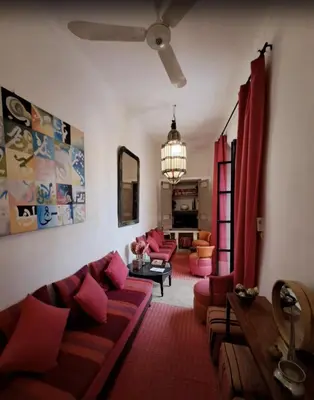a living room with a couch and pink pillows at Riad Slima - riad privatisé -Marrakech au coeur de la médina 1 Acheminement compris Aéroport riad in Marrakech