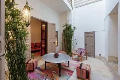 a living room with a table and chairs at Riad Slima - riad privatisé -Marrakech au coeur de la médina 1 Acheminement compris Aéroport riad in Marrakech