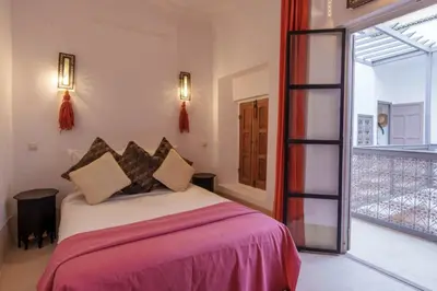 a bedroom with a bed and a large window at Riad Slima - riad privatisé -Marrakech au coeur de la médina 1 Acheminement compris Aéroport riad in Marrakech