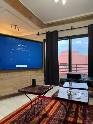 a living room with two tables and a large screen at A1, Central, Old-City 7Min on feet, good equipped in Geliz, Bab-Dokala, Majorelle, No taxi needed in Marrakech